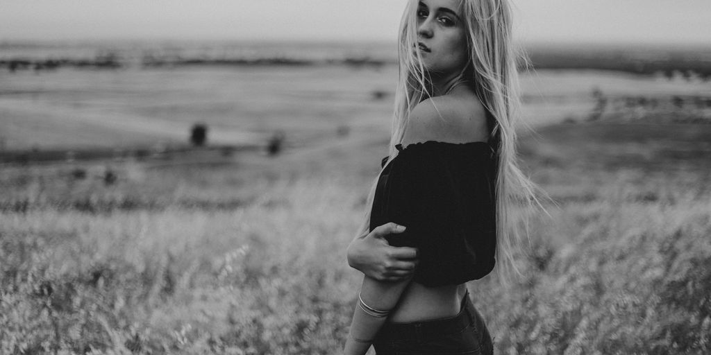 woman in black off-shoulder crop-top standing on grass field