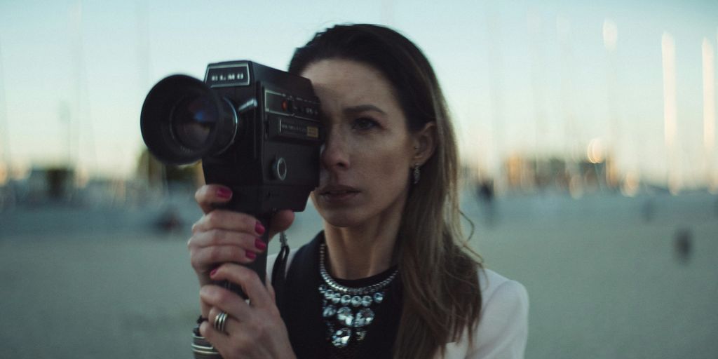 selective focus photography of woman holding camera