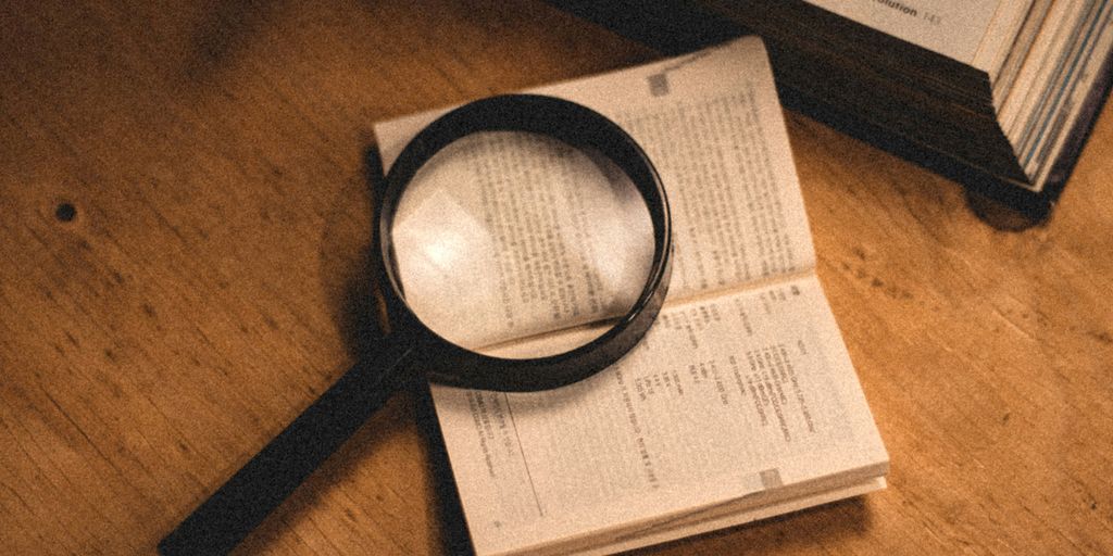 a magnifying glass sitting on top of an open book