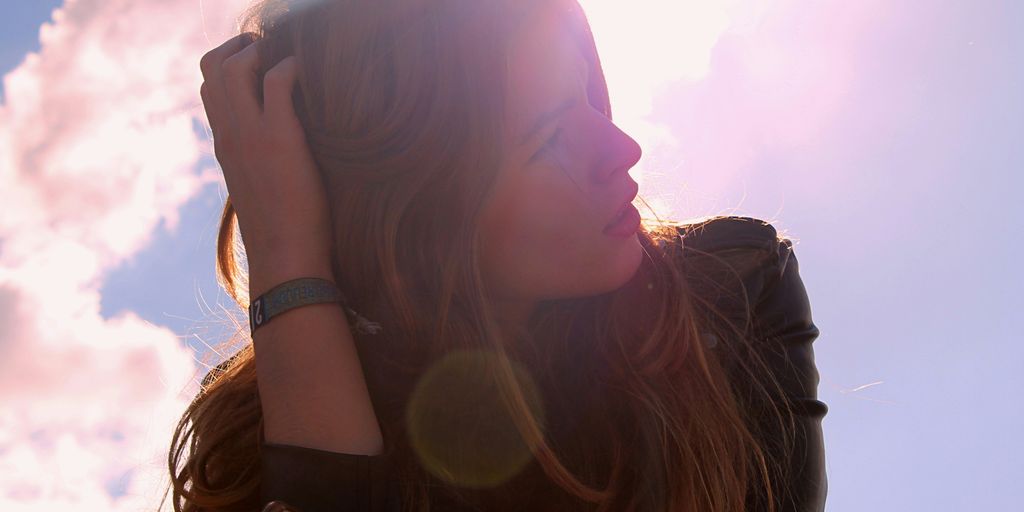 woman in black top holding her hair looking up