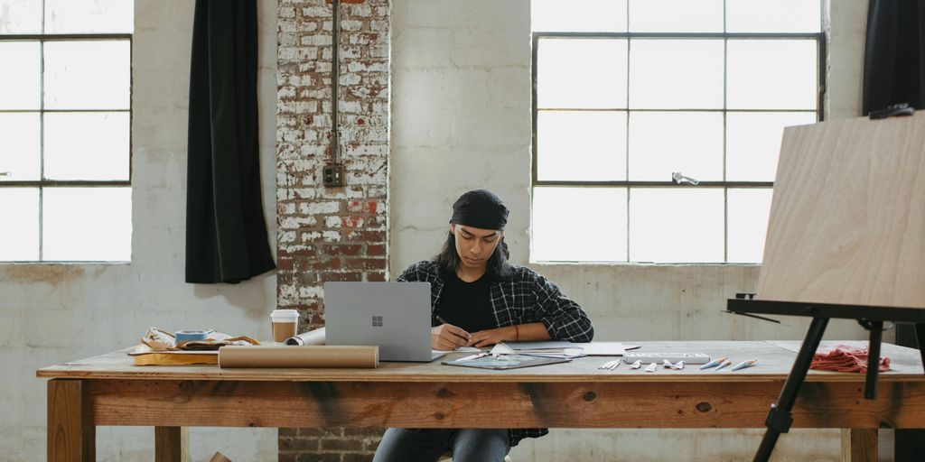 a man sitting at a table working on a laptop